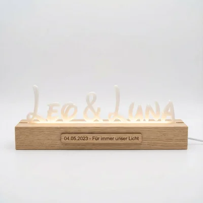 Leuchtender Namensschriftzug mit Holzsockel